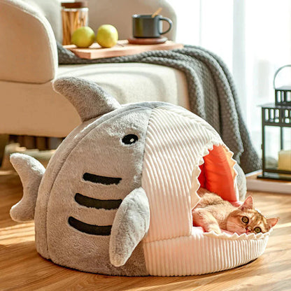 Cat lying inside a shark-shaped pet bed in a cozy living room.