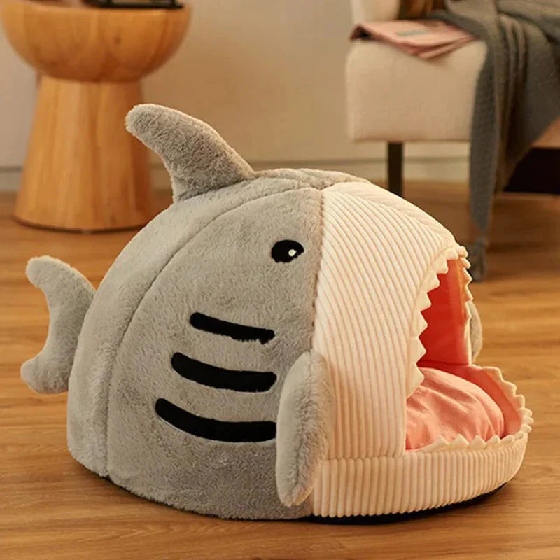 Shark-shaped pet bed on a wooden floor with a blurred background