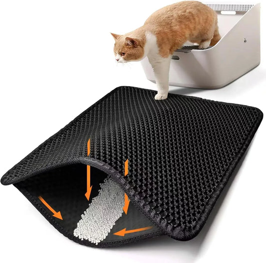 Cat using a black mat with orange arrows next to a litter box on a white background