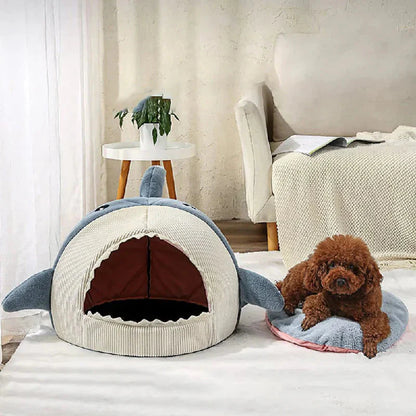 Dog lying on a shark-shaped pet bed in a cozy room.